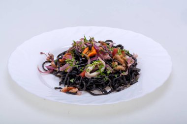 Deniz ürünleri ve sebze ile siyah spagetti