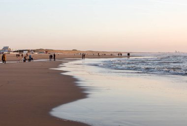Katwijk, Hollanda - 23 Nisan 2017: Güneşli bir günde Katwijk plaj boyunca insanlar yürüyor. Hollanda
