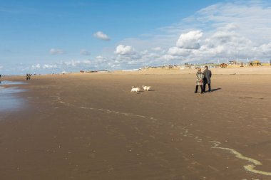 Katwijk, Hollanda - 23 Nisan 2017: Güneşli bir günde Katwijk plaj boyunca insanlar yürüyor. Hollanda