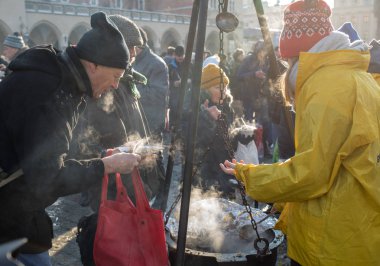 Krakov, Polonya - 16 Aralık 2018: Noel arifesi yoksul ve Cracow ana meydanında evsizlere için. Her yıl grup Kosciuszko Cracow açık havada büyük eve hazırlar. Polonya