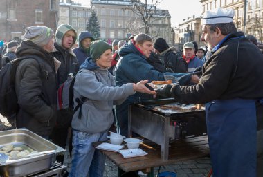 Krakov, Polonya - 16 Aralık 2018: Noel arifesi yoksul ve Cracow ana meydanında evsizlere için. Her yıl grup Kosciuszko Cracow açık havada büyük eve hazırlar. Polonya
