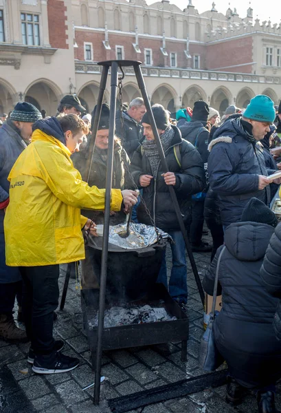 Krakov, Polonya - 16 Aralık 2018: Noel arifesi yoksul ve Cracow ana meydanında evsizlere için. Her yıl grup Kosciuszko Cracow açık havada büyük eve hazırlar. Polonya
