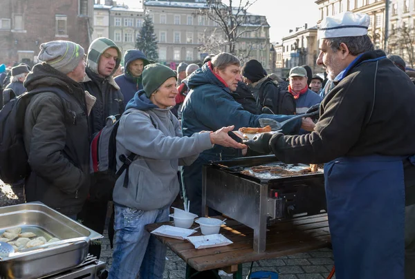 Krakov, Polonya - 16 Aralık 2018: Noel arifesi yoksul ve Cracow ana meydanında evsizlere için. Her yıl grup Kosciuszko Cracow açık havada büyük eve hazırlar. Polonya