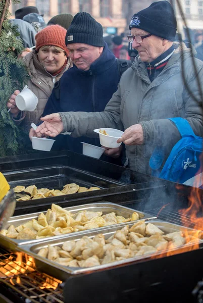 Krakov, Polonya - 16 Aralık 2018: Noel arifesi yoksul ve Cracow ana meydanında evsizlere için. Her yıl grup Kosciuszko Cracow açık havada büyük eve hazırlar. Polonya