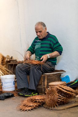 Camacha, Madeira, Portekiz - 19 Nisan 2018: Portekiz 'in Madeira Adası' ndaki Camacha 'daki fabrikada çalışan bir sepet dokumacı 