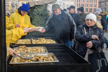Krakov, Polonya - 16 Aralık 2018: Noel arifesi yoksul ve Cracow ana meydanında evsizlere için. Her yıl grup Kosciuszko Cracow açık havada büyük eve hazırlar. Polonya