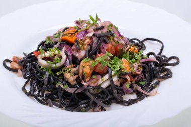 Deniz ürünleri ve sebze ile siyah spagetti