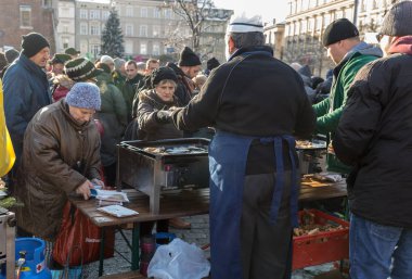Krakov, Polonya - 16 Aralık 2018: Noel arifesi yoksul ve Cracow ana meydanında evsizlere için. Her yıl grup Kosciuszko Cracow açık havada büyük eve hazırlar. Polonya