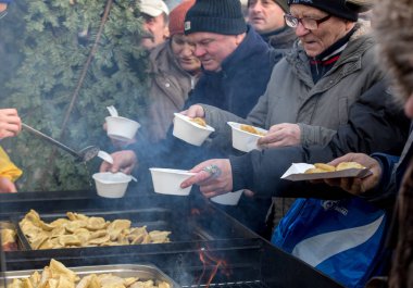 Krakov, Polonya - 16 Aralık 2018: Noel arifesi yoksul ve Cracow ana meydanında evsizlere için. Her yıl grup Kosciuszko Cracow açık havada büyük eve hazırlar. Polonya