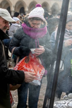 Krakov, Polonya - 16 Aralık 2018: Noel arifesi yoksul ve Cracow ana meydanında evsizlere için. Her yıl grup Kosciuszko Cracow açık havada büyük eve hazırlar. Polonya