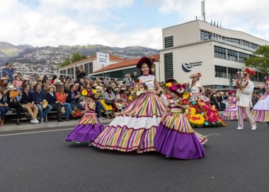 Funchal; Madeira; Portekiz - 22 Nisan; 2018: bir grup insan renkli kostümleri dans Madeira çiçek Festivali geçit töreninde Funchal, Madeira Adası üzerinde. Portekiz.