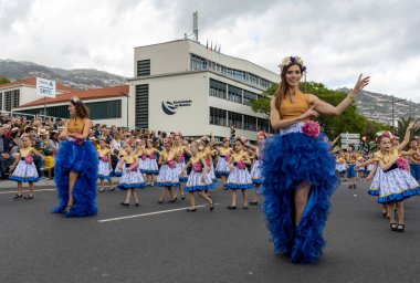 Funchal; Madeira; Portekiz - 22 Nisan; 2018: bir grup insan renkli kostümleri dans Madeira çiçek Festivali geçit töreninde Funchal, Madeira Adası üzerinde. Portekiz.