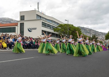 Funchal; Madeira; Portekiz - 22 Nisan; 2018: bir grup kadın renkli kostümleri dans Madeira çiçek Festivali geçit töreninde Funchal, Madeira Adası üzerinde. Portekiz.