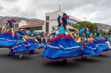 Funchal; Madeira; Portekiz - 22 Nisan; 2018: bir grup insan renkli kostümleri dans Madeira çiçek Festivali geçit töreninde Funchal, Madeira Adası üzerinde. Portekiz.
