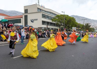 Funchal; Madeira; Portekiz - 22 Nisan; 2018: bir grup insan renkli kostümleri dans Madeira çiçek Festivali geçit töreninde Funchal, Madeira Adası üzerinde. Portekiz.