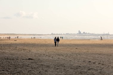 Katwijk, Hollanda - 23 Nisan 2017: Güneşli bir günde Katwijk plaj boyunca insanlar yürüyor. Hollanda