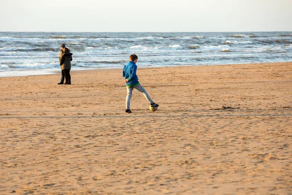 Katwijk, Hollanda - 23 Nisan 2017: Güneşli bir günde Katwijk plaj boyunca insanlar yürüyor. Hollanda