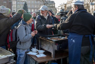 Krakov, Polonya - 16 Aralık 2018: Noel arifesi yoksul ve Cracow ana meydanında evsizlere için. Her yıl grup Kosciuszko Cracow açık havada büyük eve hazırlar. Polonya