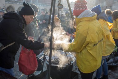 Krakov, Polonya - 16 Aralık 2018: Noel arifesi yoksul ve Cracow ana meydanında evsizlere için. Her yıl grup Kosciuszko Cracow açık havada büyük eve hazırlar. Polonya
