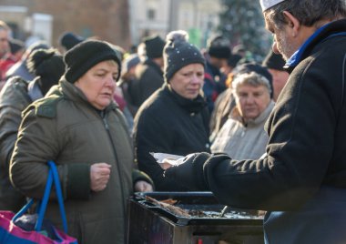 Krakov, Polonya - 16 Aralık 2018: Noel arifesi yoksul ve Cracow ana meydanında evsizlere için. Her yıl grup Kosciuszko Cracow açık havada büyük eve hazırlar. Polonya