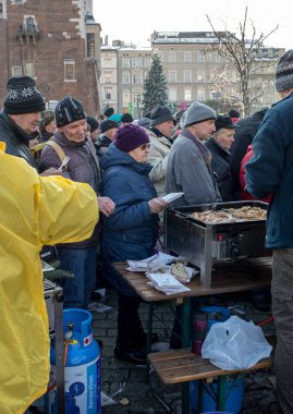 Krakov, Polonya - 16 Aralık 2018: Noel arifesi yoksul ve Cracow ana meydanında evsizlere için. Her yıl grup Kosciuszko Cracow açık havada büyük eve hazırlar. Polonya