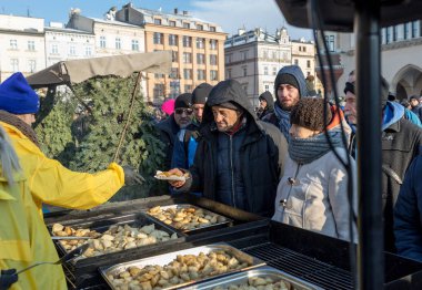 Krakov, Polonya - 16 Aralık 2018: Noel arifesi yoksul ve Cracow ana meydanında evsizlere için. Her yıl grup Kosciuszko Cracow açık havada büyük eve hazırlar. Polonya
