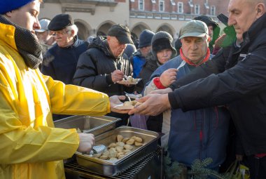 Krakov, Polonya - 16 Aralık 2018: Noel arifesi yoksul ve Cracow ana meydanında evsizlere için. Her yıl grup Kosciuszko Cracow açık havada büyük eve hazırlar. Polonya