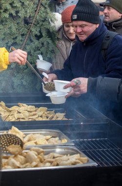 Krakov, Polonya - 16 Aralık 2018: Noel arifesi yoksul ve Cracow ana meydanında evsizlere için. Her yıl grup Kosciuszko Cracow açık havada büyük eve hazırlar. Polonya