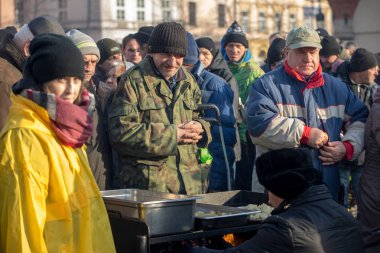 Krakov, Polonya - 16 Aralık 2018: Noel arifesi yoksul ve Cracow ana meydanında evsizlere için. Her yıl grup Kosciuszko Cracow açık havada büyük eve hazırlar. Polonya