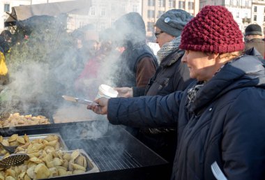 Krakov, Polonya - 16 Aralık 2018: Noel arifesi yoksul ve Cracow ana meydanında evsizlere için. Her yıl grup Kosciuszko Cracow açık havada büyük eve hazırlar. Polonya