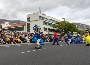 Funchal; Madeira; Portekiz - 22 Nisan; 2018: bir grup insan renkli kostümleri dans Madeira çiçek Festivali geçit töreninde Funchal, Madeira Adası üzerinde. Portekiz.