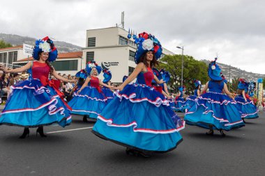 Funchal; Madeira; Portekiz - 22 Nisan; 2018: bir grup kadın renkli kostümleri dans Madeira çiçek Festivali geçit töreninde Funchal, Madeira Adası üzerinde. Portekiz.