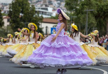 Funchal; Madeira; Portekiz - 22 Nisan; 2018: bir grup kadın renkli kostümleri dans Madeira çiçek Festivali geçit töreninde Funchal, Madeira Adası üzerinde. Portekiz.