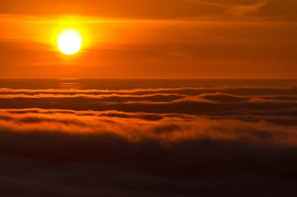 Dreamy misty landscape above the sea of clouds, mountains at sunset in Iceland