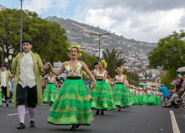 Funchal; Madeira; Portekiz - 22 Nisan; 2018: bir grup insan ayçiçeği motifli renkli elbiseler dans Madeira çiçek Festivali geçit töreninde Funchal, Madeira Adası üzerinde. Portekiz.