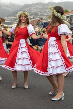 Funchal; Madeira; Portekiz - 22 Nisan; 2018: bir grup kadın kırmızı ve beyaz elbiseler dans Madeira çiçek Festivali geçit töreninde Funchal, Madeira Adası üzerinde. Portekiz.