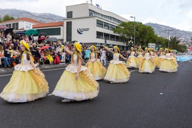 Funchal; Madeira; Portekiz - 22 Nisan; 2018: bir grup kadın sarı kostümleri dans Madeira çiçek Festivali geçit töreninde Funchal, Madeira Adası üzerinde. Portekiz.
