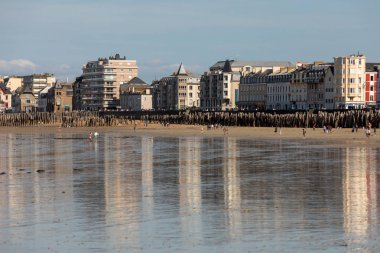 St. Malo, Fransa - 15 Eylül 2018: Saint Malo 'nun pitoresk plajında gün batımından önce insanların romantik yürüyüşü. Britanya, Fransa
