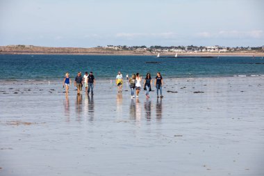 St. Malo, Fransa - 15 Eylül 2018: Saint Malo 'nun pitoresk plajında gün batımından önce insanların romantik yürüyüşü. Britanya, Fransa