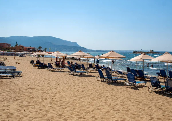 Malia, Girit, Yunanistan-Juni 18, 2019: Insanlar Malia, Girit, Yunanistan plajda güneşli bir günde dinleniyor