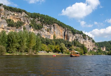 La Roque-Gageac, Dordogne, Fransa - 7 Eylül 2018: Kano ve turist botu, Fransızcada gabare, La Roque-Gageac Dordogne nehri ve arka planda Chateau La Malartrie. Aquitaine, Fransa