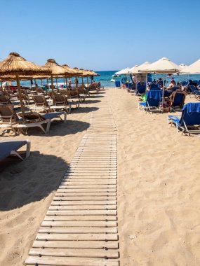 Malia, Girit, Yunanistan-Juni 18, 2019: Insanlar Malia, Girit, Yunanistan plajda güneşli bir günde dinleniyor