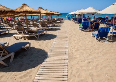 Malia, Girit, Yunanistan-Juni 18, 2019: Insanlar Malia, Girit, Yunanistan plajda güneşli bir günde dinleniyor