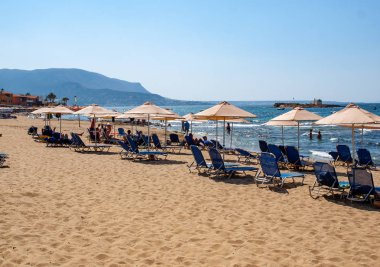 Malia, Girit, Yunanistan-Juni 18, 2019: Insanlar Malia, Girit, Yunanistan plajda güneşli bir günde dinleniyor