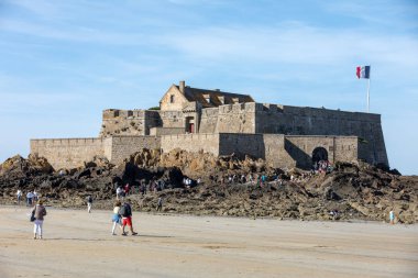 St. Malo, Fransa - 15 Eylül 2018: Saint Malo 'nun pitoresk plajında gün batımından önce insanların romantik yürüyüşü. Britanya, Fransa