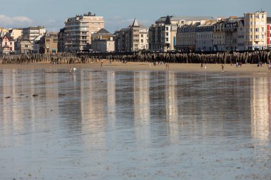 St. Malo, Fransa - 15 Eylül 2018: Saint Malo 'nun pitoresk plajında gün batımından önce insanların romantik yürüyüşü. Britanya, Fransa
