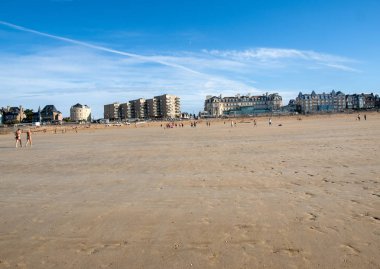 St. Malo, Fransa - 16 Eylül 2018: Saint Malo 'nun pitoresk plajında gün batımından önce insanların romantik yürüyüşü. Britanya, Fransa