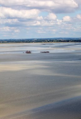 Koyda bir grup yürüyüşçü alçak gelgitte. Bilge bir rehberle körfezde yürüyüş yapmak. Mont Saint-Michel, Normandiya, Fransa 
