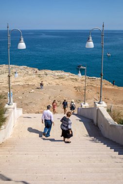 Polignano, İtalya - 17 Eylül 2019: İnsanlar Polignano a Mare, Adriyatik Denizi, Apulia, Bari ili, İtalya 'daki sevimli Lama Monachile plajında dinleniyor ve yüzüyorlar,