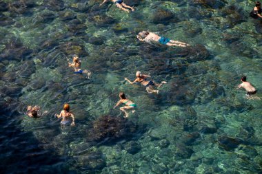 Polignano a Mare, İtalya - 17 Eylül 2019: İnsanlar Polignano a Mare, Adriyatik Denizi, Apulia, Bari ili, İtalya 'daki sevimli Lama Monachile plajında dinleniyor ve yüzüyorlar,